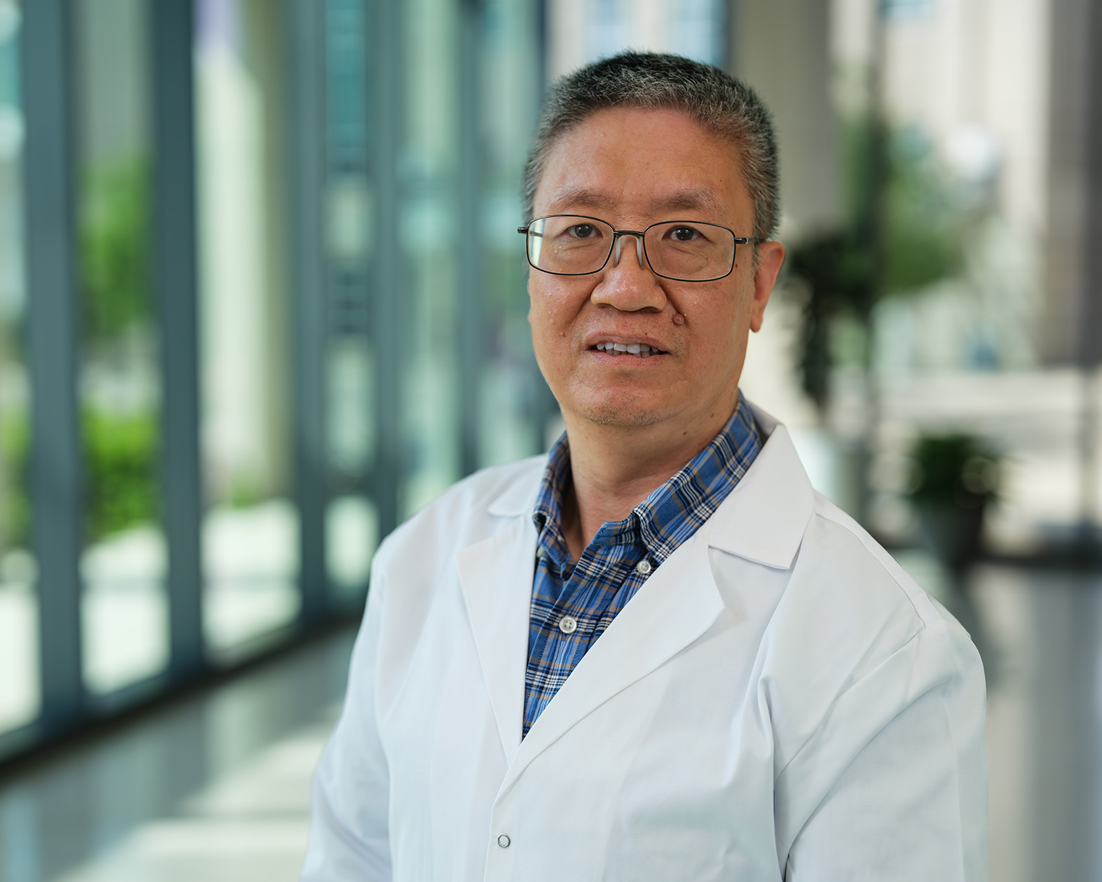 De-Pei Li stands in the atrium of the Roy Blunt NextGen Precision Health building.