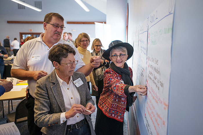 Group of people working on a whiteboard at an MU Extension workshop